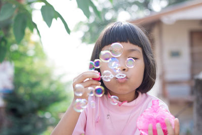 Girl making bubbles with wand