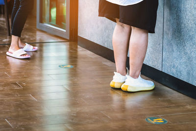 Low section of people standing on floor at home
