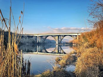 Arch bridge over river against sky