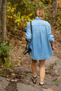 Rear view of woman walking in forest