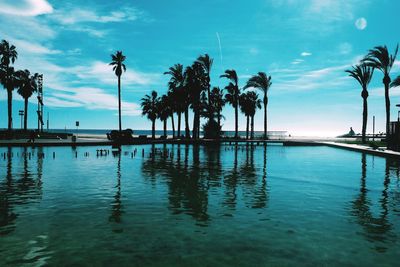 Swimming pool by sea against sky during sunset