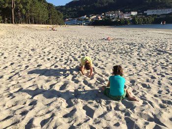 Rear view of children playing on beach