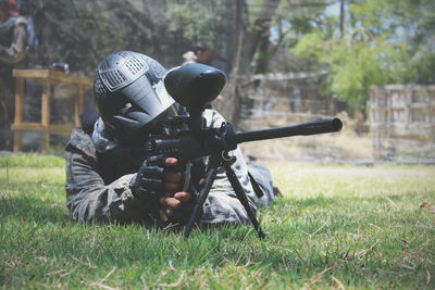 Army man using weapon on grassland