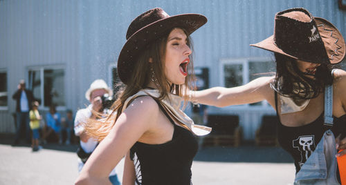 Portrait of young woman in hat standing outdoors