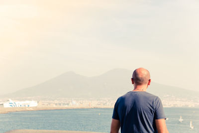 Rear view of man against sea and sky