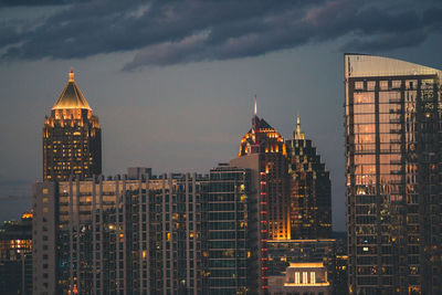 Illuminated cityscape against sky during sunset