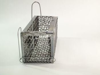 Close-up of metal basket on table against wall
