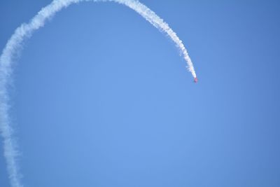 Low angle view of vapor trail against clear blue sky