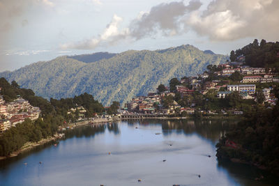 Scenic view of townscape by mountains against sky