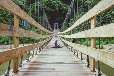 Man on footbridge in forest