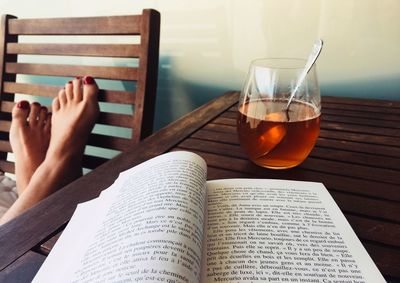 Low section of man reading book on table