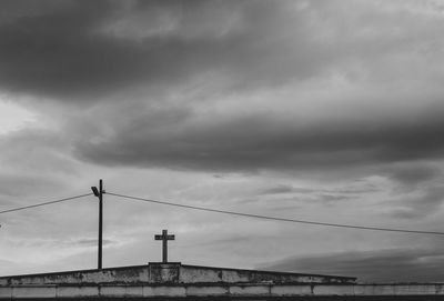 Low angle view of bridge against cloudy sky