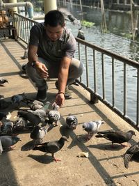 Full length of man and birds in water