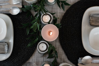 Sky view of a large candle on a dinner table setting for two