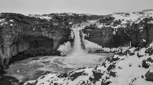 Scenic view of waterfall against sky during winter