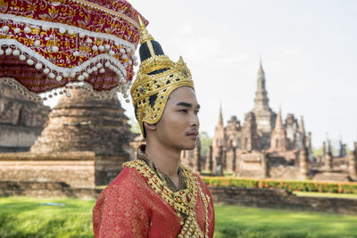 Portrait of mid adult man outside temple against building