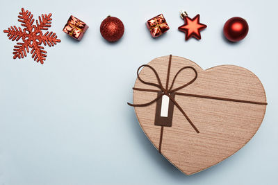 High angle view of heart shape box with christmas decoration over blue background