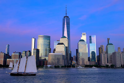 Sea by modern buildings against sky in city