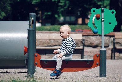 Boy sitting on slide at playground
