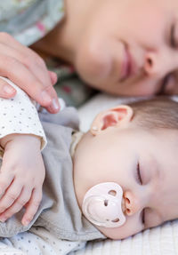 Midsection of baby lying on bed