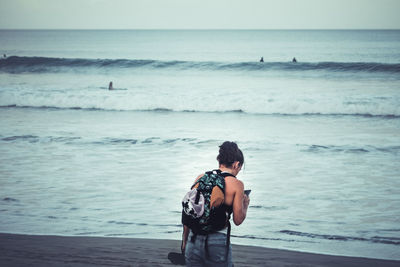 Woman using mobile phone at beach