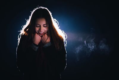 Portrait of beautiful young woman over black background