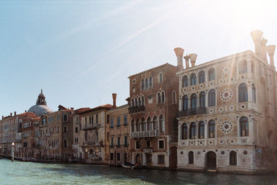 View of canal by buildings against sky