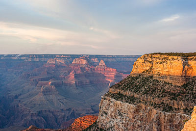 Rock formations on landscape against cloudy sky