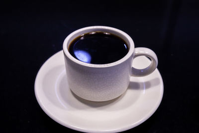 Close-up of coffee cup over black background