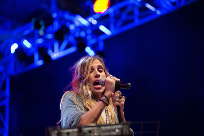 Full length of young woman with arms raised