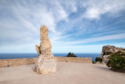 Rock formation on beach against sky