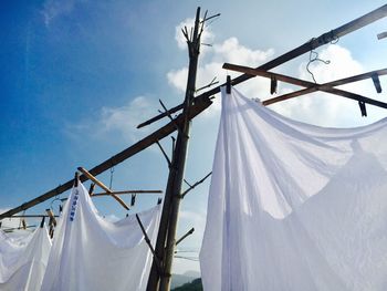 Low angle view of clothes hanging on clothesline against sky