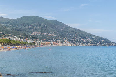 Aerial view of townscape by sea against sky