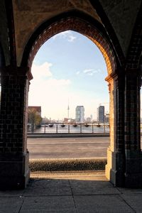 Distant view of fernsehturm tower seen through oberbaum bridge arch