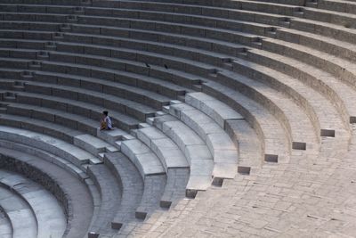 High angle view of woman sitting on staircase at amphitheater