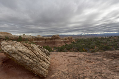 Rock formations on landscape against cloudy sky