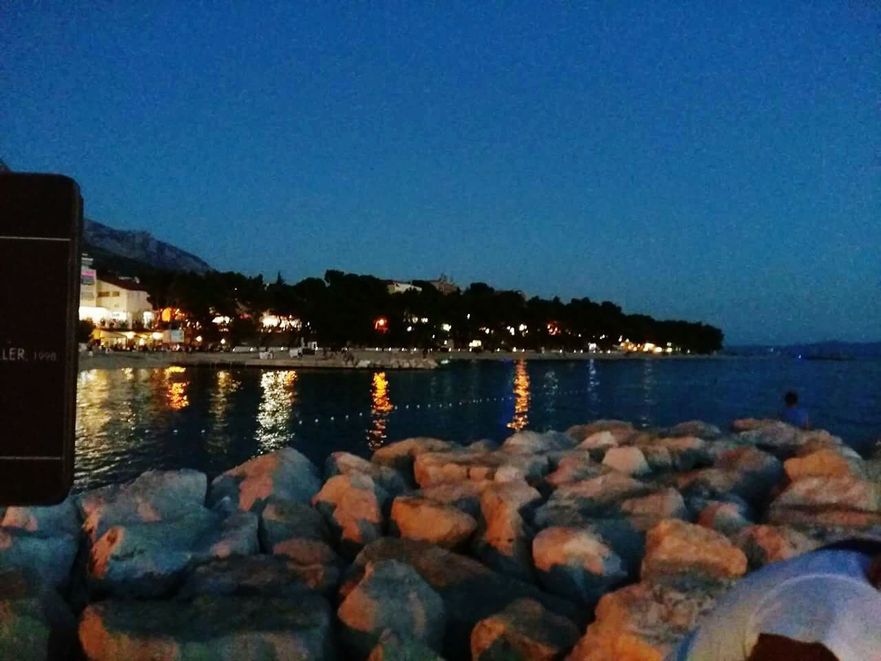 water, clear sky, sea, illuminated, night, rock - object, blue, scenics, shore, tranquil scene, tranquility, nature, sky, beauty in nature, outdoors, idyllic, calm, no people