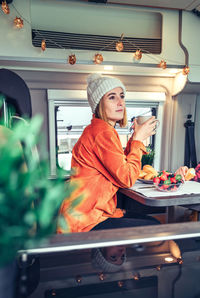 Woman having breakfast in a camper van