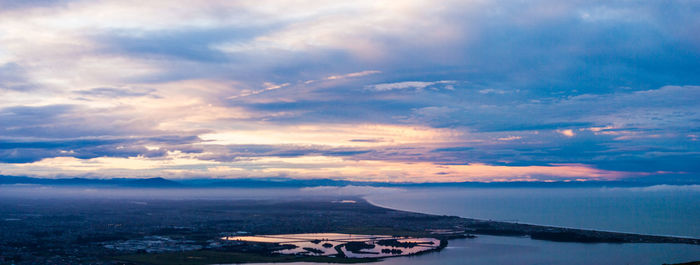 High angle view of city by sea against sky