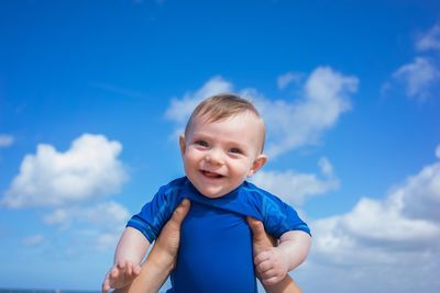 Portrait of baby boy against blue sky