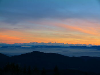 Scenic view of silhouette mountains against sky at sunset