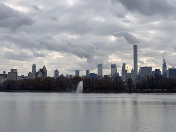 City by lake against sky