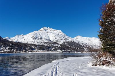 Scenic view of snowcapped mountains against clear blue sky