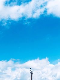 Low angle view of smoke stacks against blue sky