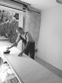 Young woman sitting on wall at home