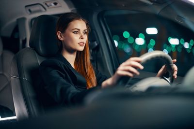 Beautiful woman driving car at night