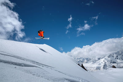 Person skiing on snowcapped mountain against sky