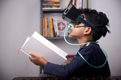 Side view of boy holding book