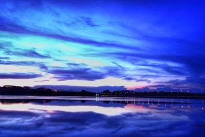 Scenic view of calm lake against cloudy sky