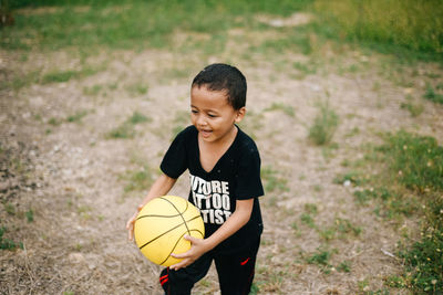 Boy playing with ball on field